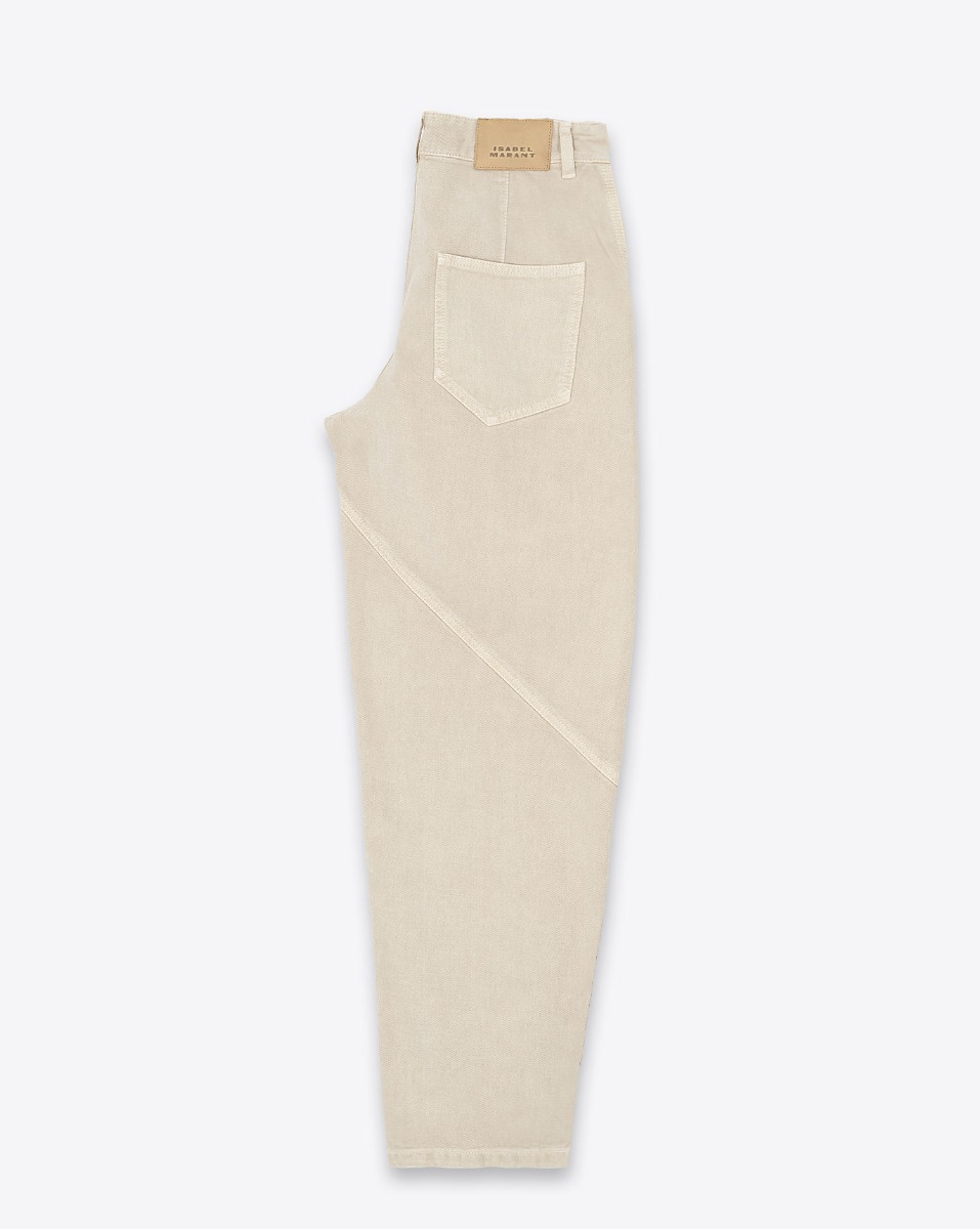 Jean Catarina Isabel Marant en denim écru. Forme large taille haute. Détail de coutures surpiqués. Profil. Détail de l'étiquette en cuir avec logo embossé "Isabel Marant"