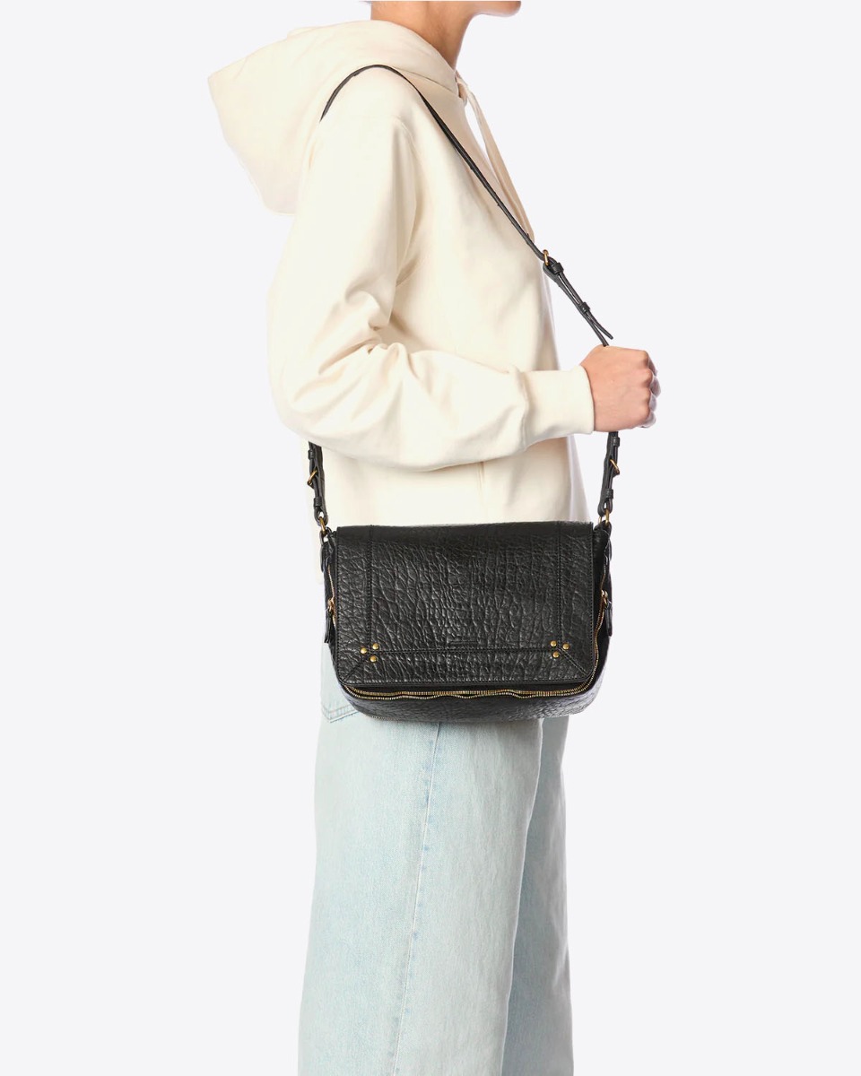 Sac Igor Jérôme Dreyfuss en cuir bubble noir porté à l'épaule.