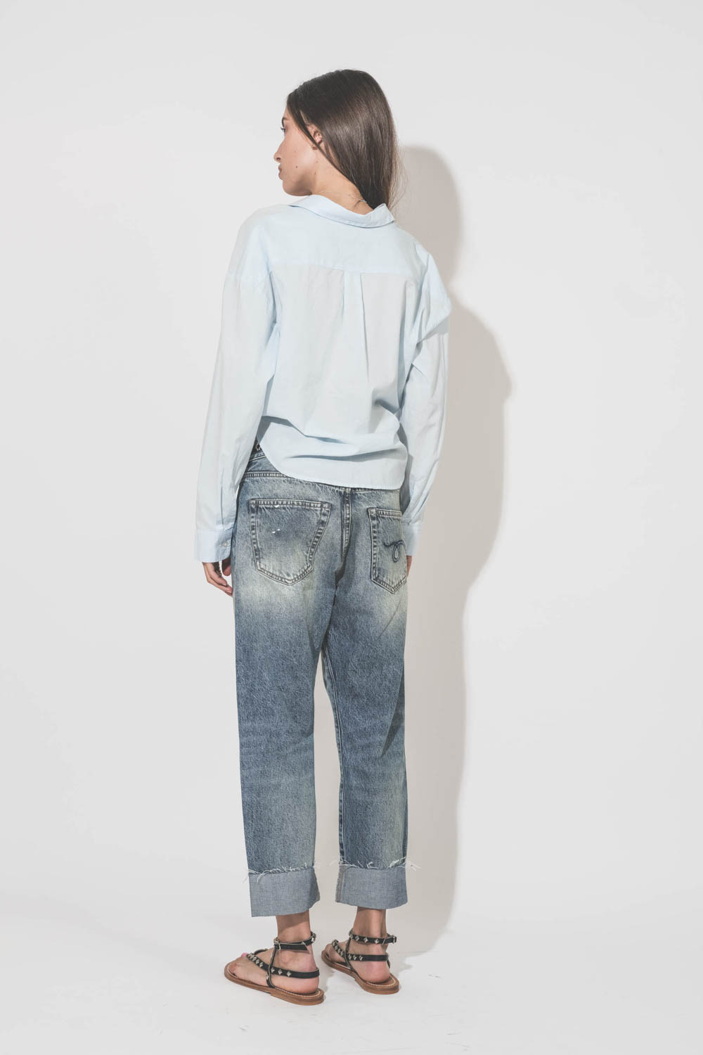 Sandales plates cloutées en cuir noir Deltapyr K.Jacques St Tropez. Porté de dos avec un jean Croosover R13 denim. 