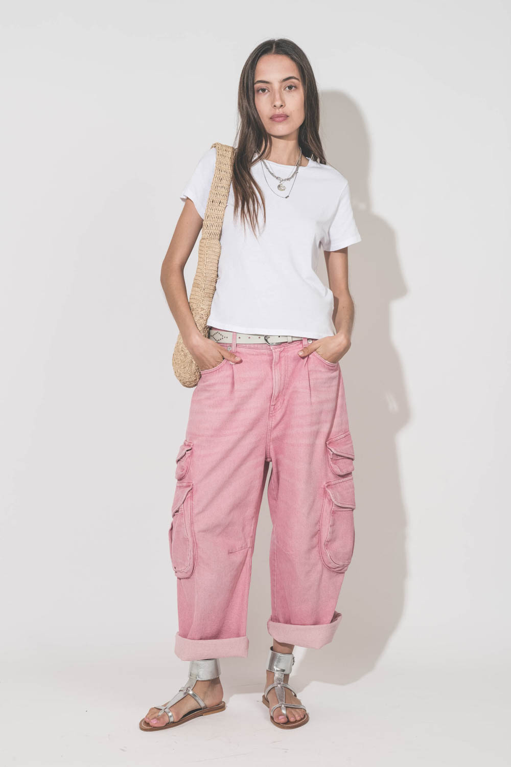 Sandales plates bracelet de cheville en cuir argent Caravelle K.Jacques St-Tropez. Portées avec un tee-shirt blanc Little The Great, un jean Cargo rose R13, une ceinture en cuir blanc Liliana Isabel Marant, un panier en raphia naturel et des colliers Mari