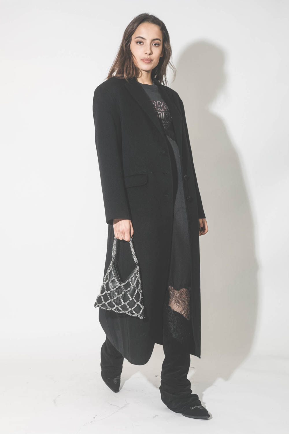 Mini-sac en cuir noir avec chaine Gaia Anine Bing. Porté avec un manteau long noir.
