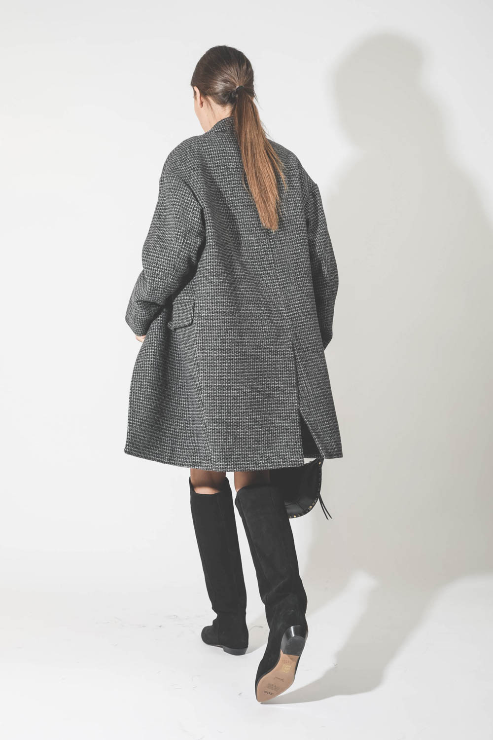 Manteau en laine pied de poule noir et gris Limiza Marant Etoile. Porté avec des bottes en cuir suédé noir.