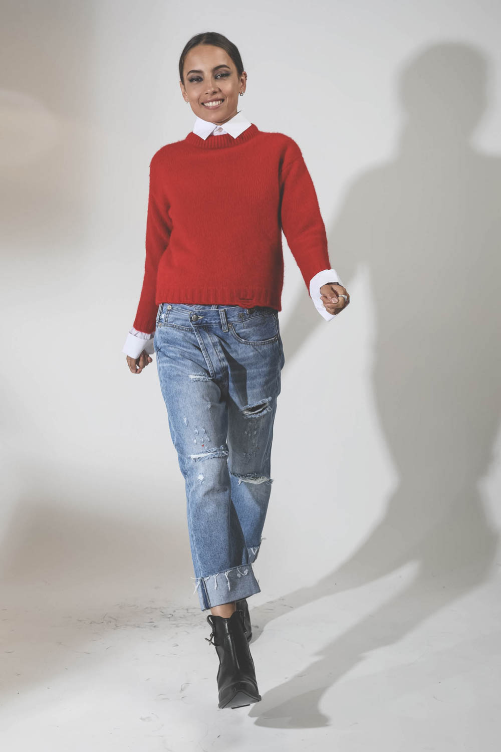 Pull court col rond en cachemire rouge bord côte démaillé R13. Porté avec un jeans Crossover.