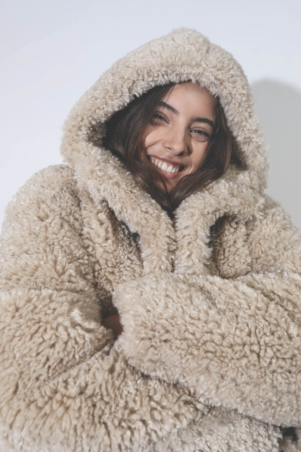 Manteau 3/4 à capuche en fausse fourrure beige Florene Marant Etoile. Porté avec la capuche relevée.