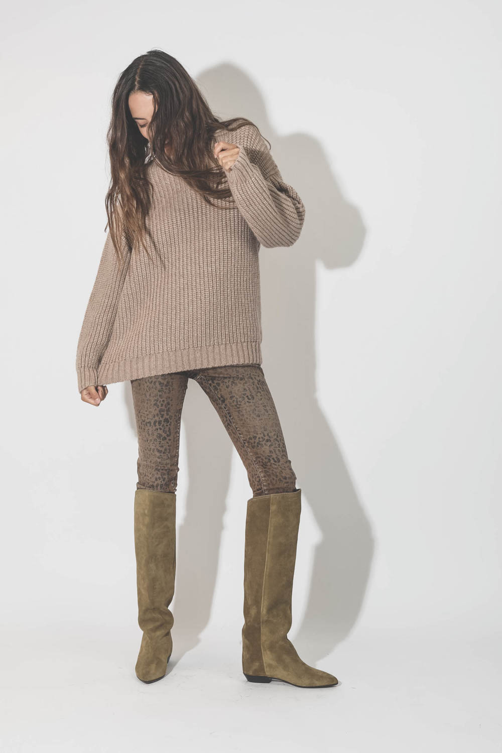 Pull col rond manches longues beige Sydney Anine Bing. Porté avec des bottes camel en cuir suédé.