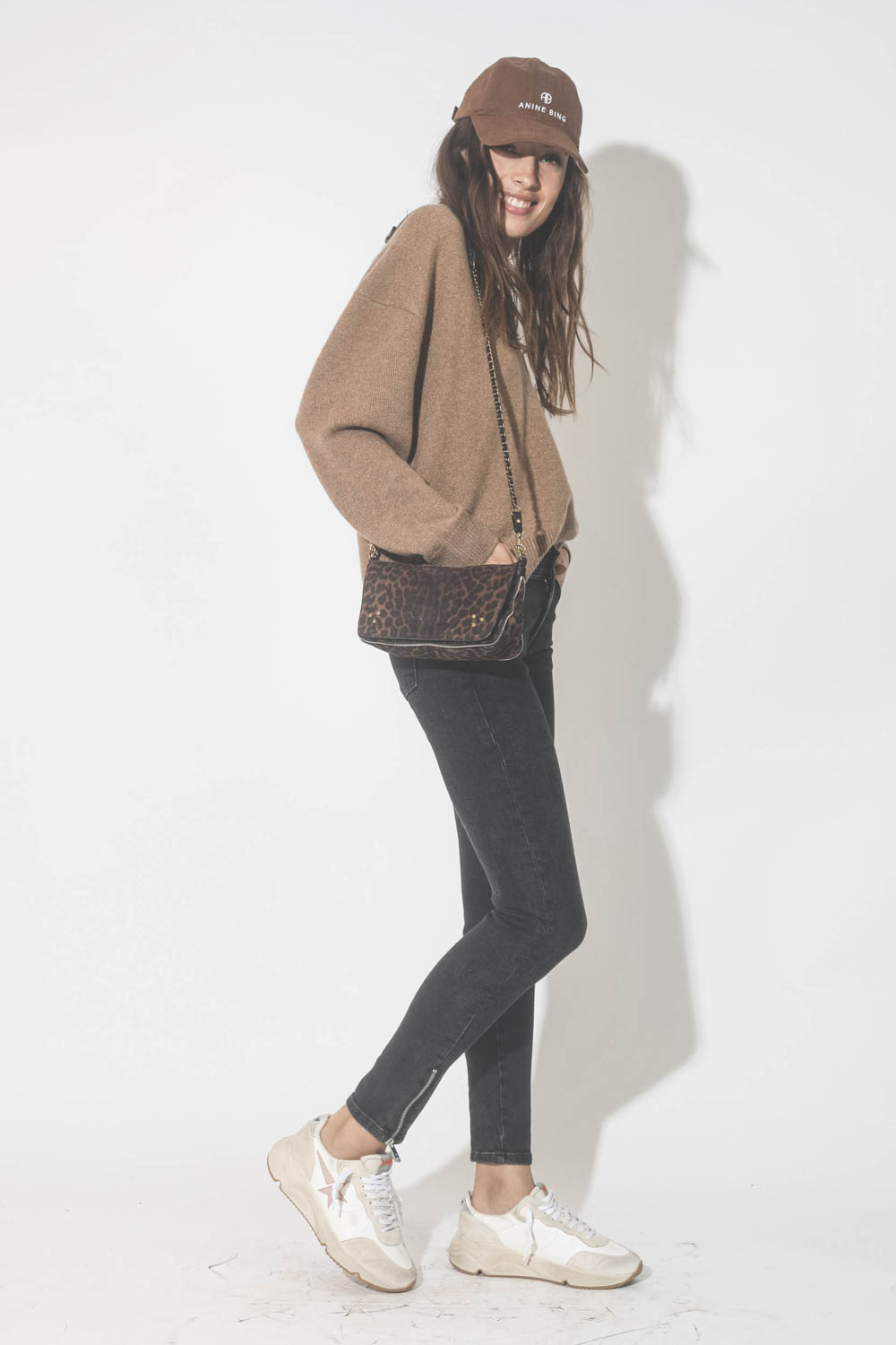 Pull col V en cachemire camel Lee Anine Bing. Porté avec un mini-sac léopard naturel.