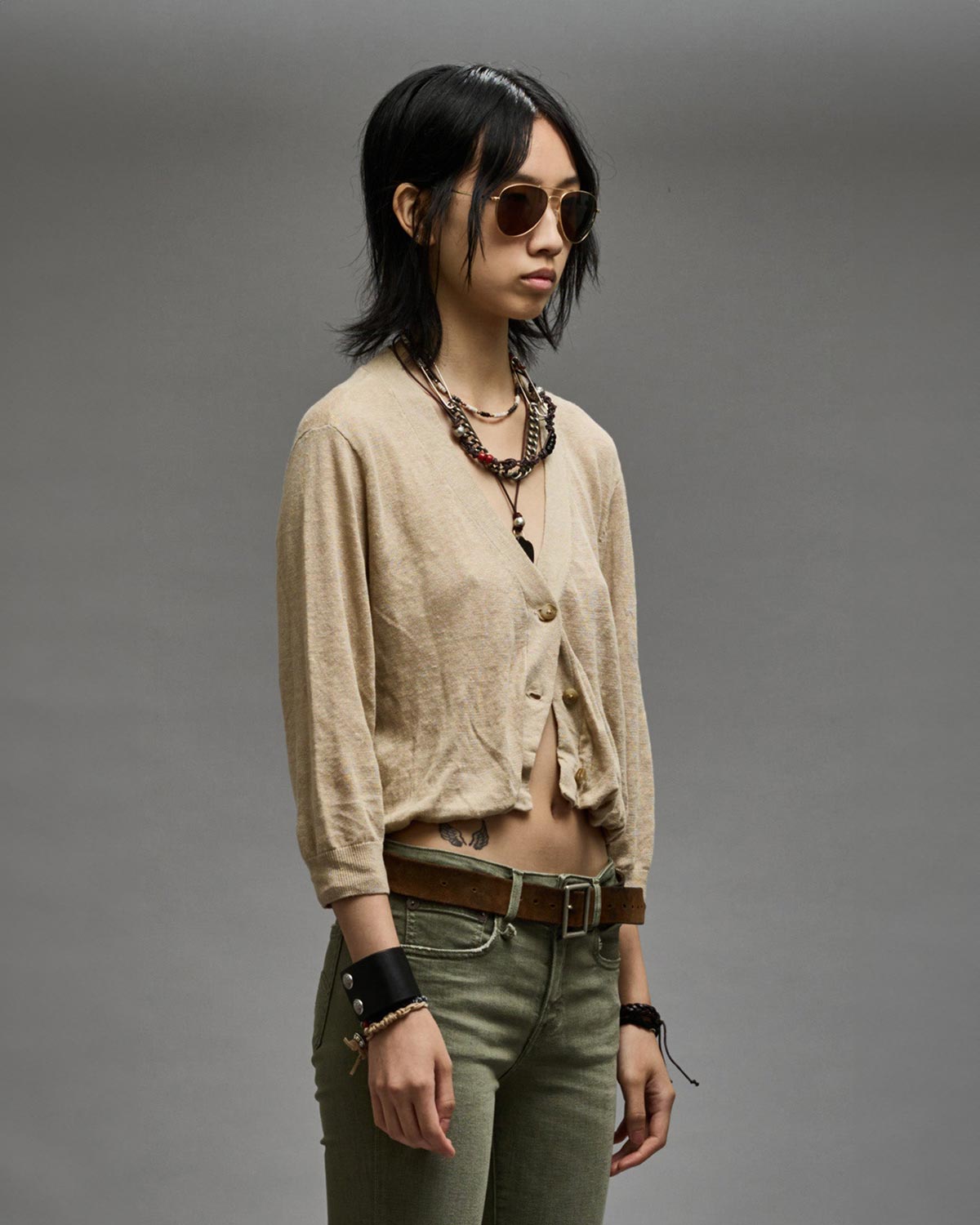Gilet manches longues court en lin beige Balloon Cardigan R13. Porté de profil.