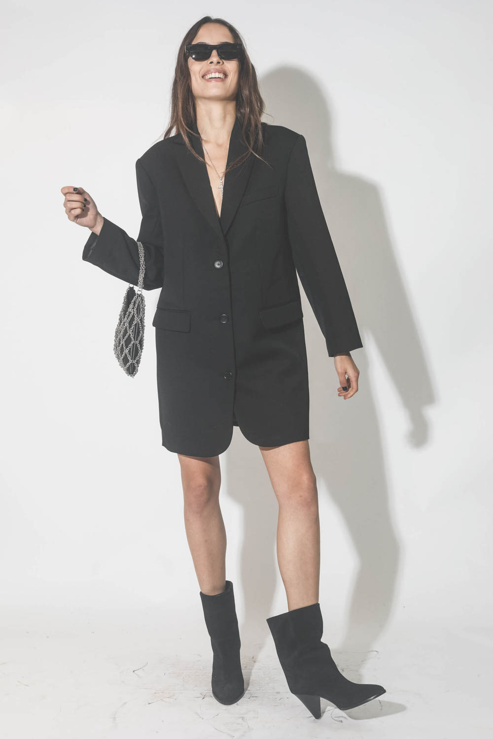 Robe courte esprit blazer noir Quinn Anine Bing. Porté avec des lunettes de soleil noires.