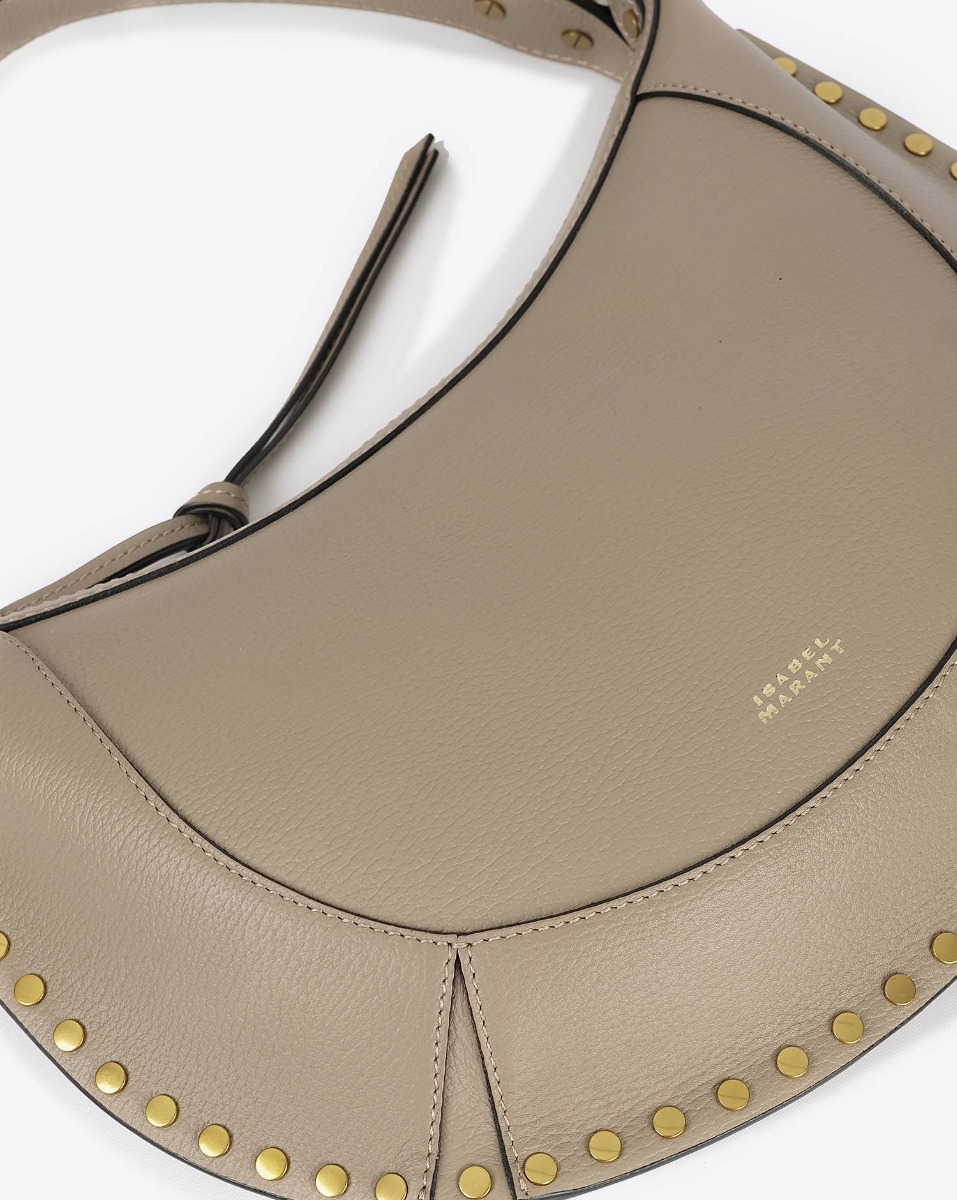 Sac Naoko Isabel Marant en cuir grainé taupe. Anse courte et bandoulière longue amovible et réglable. Porté épaule et main ou épaule et croisé. Face. Détail du logo embossé "Isabel Marant" devant.