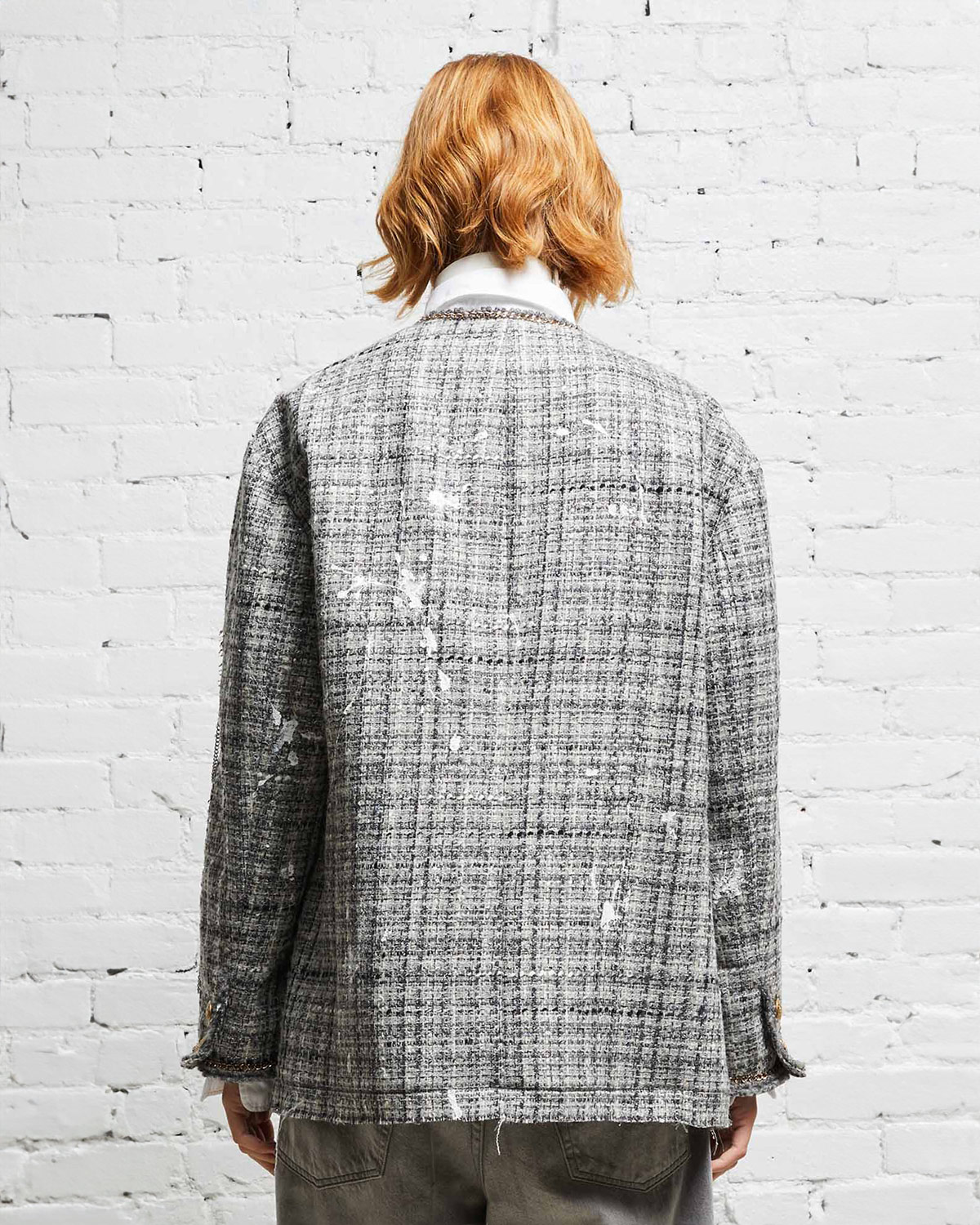 Veste oversized en tweed gris et taches de peinture avec des chaines, épingles à nourrice et badges R13. Porté de dos. 