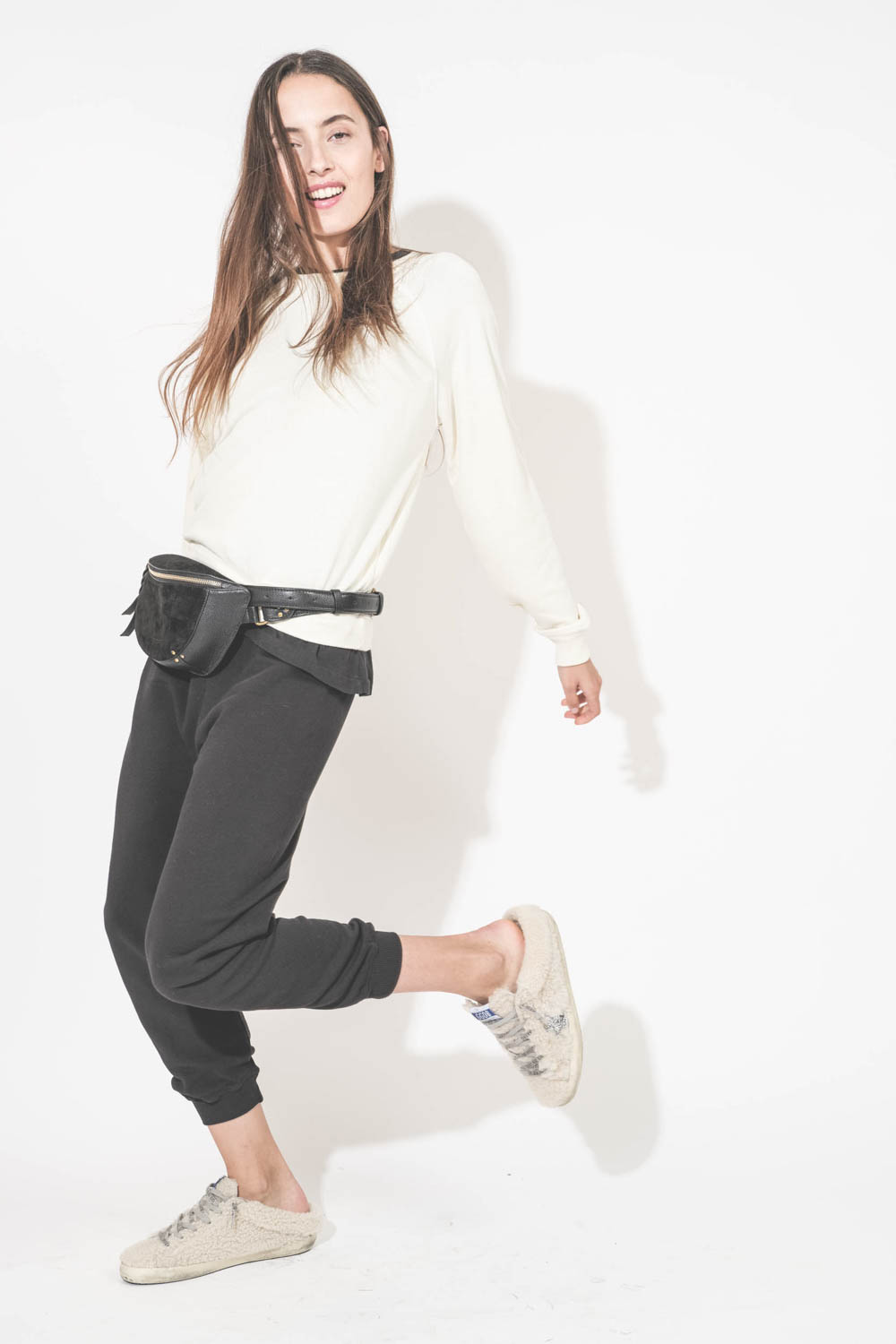 Sweat-shirt manches longues col rond en bouclette de coton écru Shrunken The Great. Porté de profil avec un bas de jogging en bouclette de coton noir Cropped The Great et des sneakers Super Star sabot en fourrure écru 10757 Golden Goose. Sac banane en cui