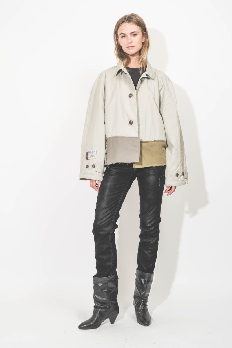 Trench court Oligos en tissus recyclés beige, création unique Yekaterina Ivankova porté de face avec un jean slim en faux cuir noir.